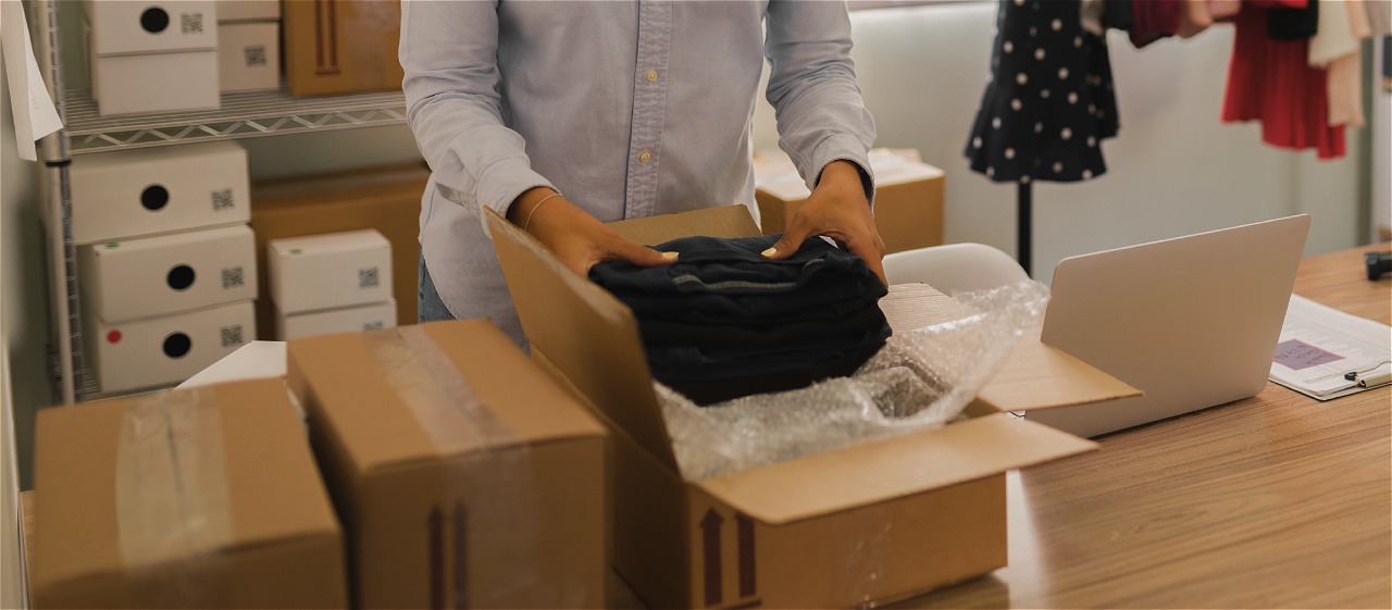 Organização de mercadorias em estoque de loja de moda, com produtos embalados e sem saída